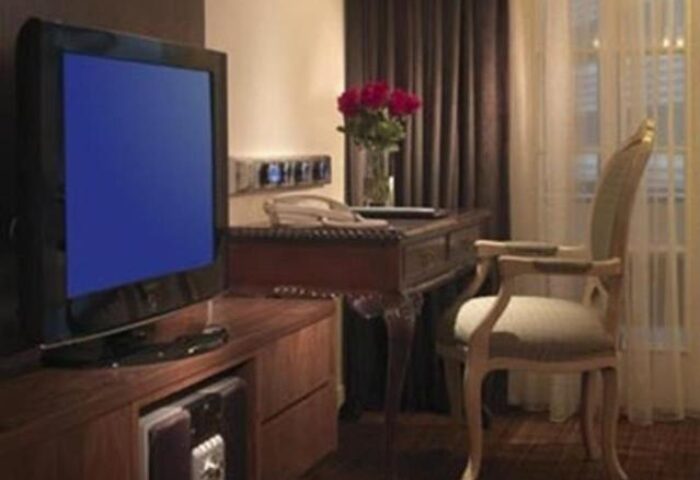 Concorde Hotel Kuala Lumpur room interior. Gay-friendly hotel with TV, desk, chair, and flowers. Comfortable stay in Kuala Lumpur.