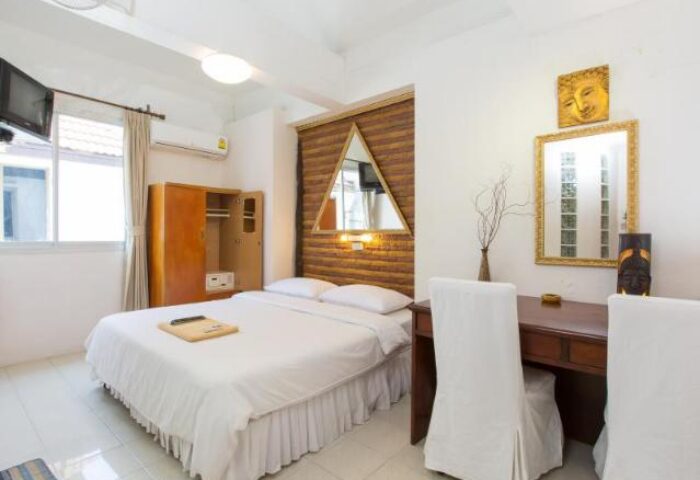 Connect Guesthouse room. Gay-friendly hotel bedroom with double bed, desk, wardrobe, and mirrors. Interior design in a modern style.