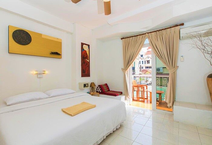 Connect Guesthouse gay-friendly hotel room. White walls, bed, balcony, and decor. A comfortable stay for gay men travelers.