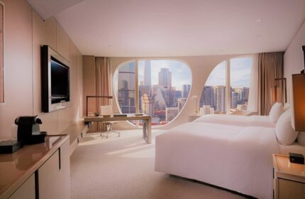 Conrad Beijing hotel room with twin beds, desk, and city view. Gay-friendly hotel for LGBTQ travelers in Beijing. Modern design.