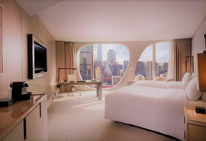 Conrad Beijing hotel room with twin beds, desk, and city view. Gay-friendly hotel for LGBTQ travelers in Beijing. Modern design.