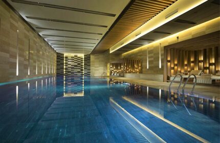 Conrad Beijing gay-friendly hotel's indoor pool. Relaxing, modern design with lounge chairs, perfect for gay men travelers in Beijing.