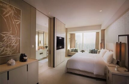 Conrad Beijing gay-friendly hotel room. Modern design, king bed, city view, and bathroom access. Luxury travel for gay men.