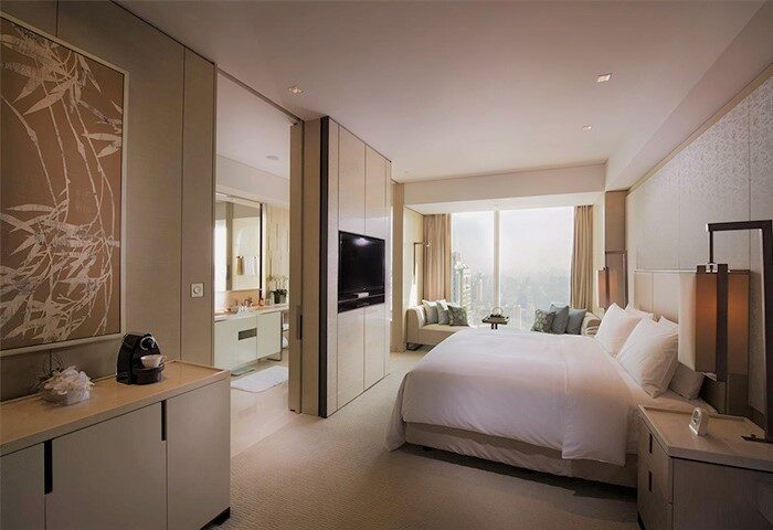 Conrad Beijing gay-friendly hotel room. Modern design, king bed, city view, and bathroom access. Luxury travel for gay men.
