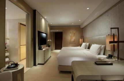 Bedroom at the gay-friendly Conrad Beijing Hotel. Two beds, desk, TV, and bathroom. Modern design for gay men's travel in Beijing.