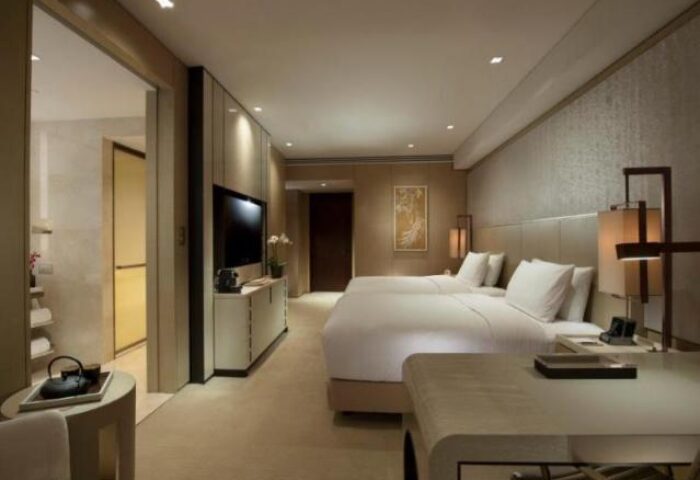 Bedroom at the gay-friendly Conrad Beijing Hotel. Two beds, desk, TV, and bathroom. Modern design for gay men's travel in Beijing.