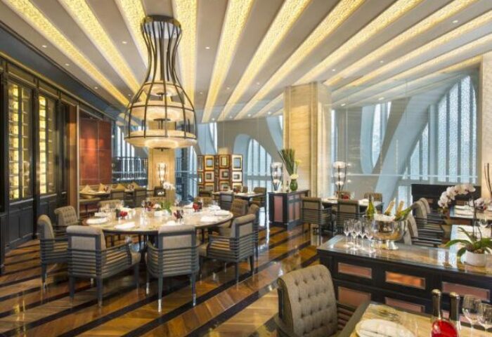 Conrad Beijing gay-friendly hotel restaurant. Dining area with modern decor, tables set for service. Upscale ambiance, perfect for gay travelers.
