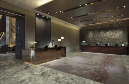 Lobby view at Conrad Beijing, a gay-friendly hotel. Check-in desks, marble floors, and modern design. A luxurious stay for gay travelers in Beijing.