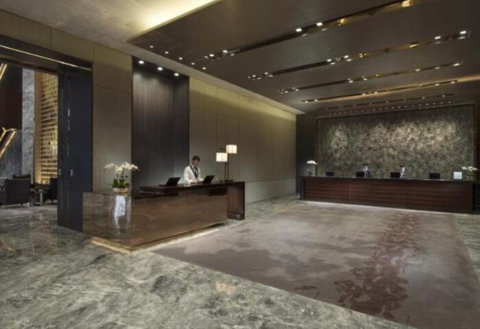 Lobby view at Conrad Beijing, a gay-friendly hotel. Check-in desks, marble floors, and modern design. A luxurious stay for gay travelers in Beijing.