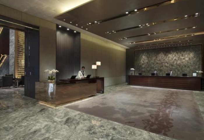 Lobby view at Conrad Beijing, a gay-friendly hotel. Check-in desks, marble floors, and modern design. A luxurious stay for gay travelers in Beijing.