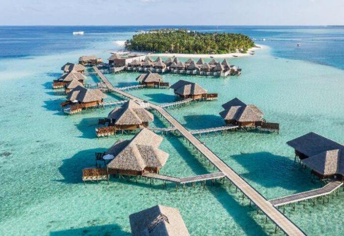 Aerial view of Conrad Maldives Rangali Island Resort's overwater bungalows. A gay-friendly hotel with luxury accommodations.