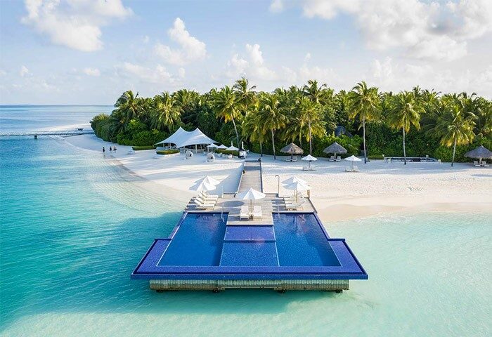Conrad Maldives Rangali Island Resort: Gay-friendly hotel with overwater pool, white sand beach, palm trees, and turquoise ocean. Ideal gay travel.