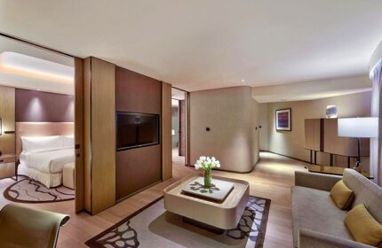 Conrad Manila gay-friendly hotel room. Modern design with a bed, TV, sofa, and coffee table. A great choice for gay travelers in Manila.