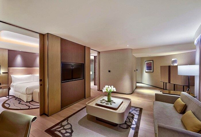Conrad Manila gay-friendly hotel room. Modern design with a bed, TV, sofa, and coffee table. A great choice for gay travelers in Manila.