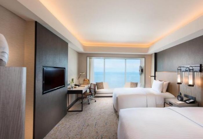 Gay-friendly Hotel Conrad Manila room. Two beds, desk, TV, and ocean view. Modern design, comfortable for gay travelers. Manila hotel room.