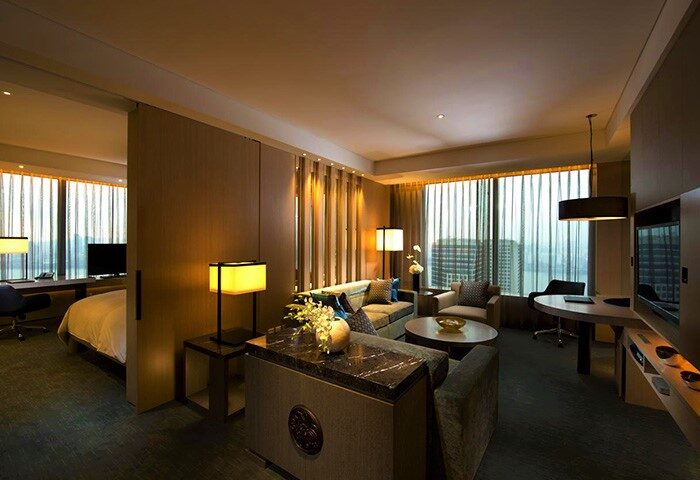 Conrad Seoul hotel suite. Gay-friendly hotel room with a living area, desk, and bedroom separated by a sliding partition. Modern design.