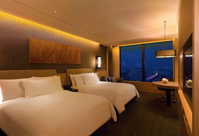 Conrad Seoul gay-friendly hotel room with two beds, city view at night. Upscale accommodations for gay travelers in Seoul, South Korea.