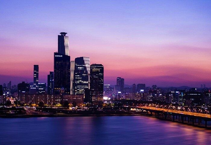 Conrad Seoul hotel skyline at dusk. Gay-friendly hotel with city view. Seoul's vibrant cityscape and Han River, perfect for LGBTQ+ travelers.