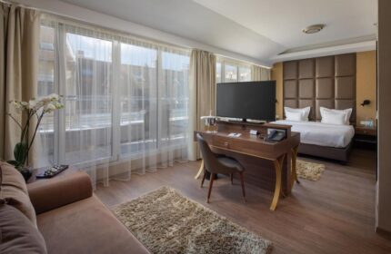 Continental Hotel room interior. Gay-friendly hotel with bed, desk, and large windows. Modern design for gay men travel.