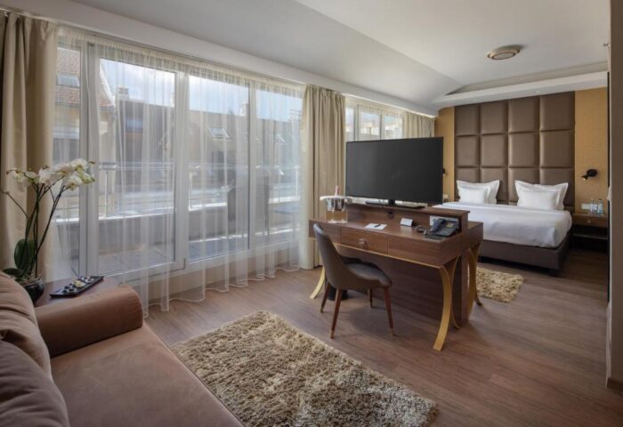 Continental Hotel room interior. Gay-friendly hotel with bed, desk, and large windows. Modern design for gay men travel.
