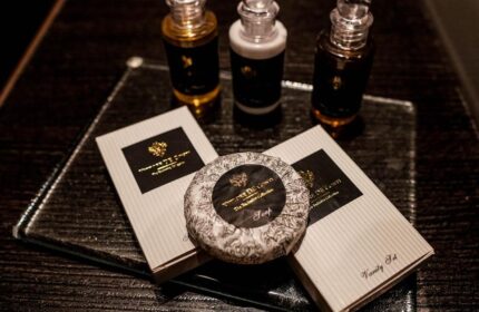 Continental Hotel's toiletries: Soap, vanity set, shampoo, and lotion on a glass tray. Gay-friendly hotel amenities detail.