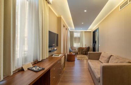 Continental Hotel room interior. Gay-friendly hotel with modern décor, sofa, desk, TV, and natural light. Ideal for gay men travel.