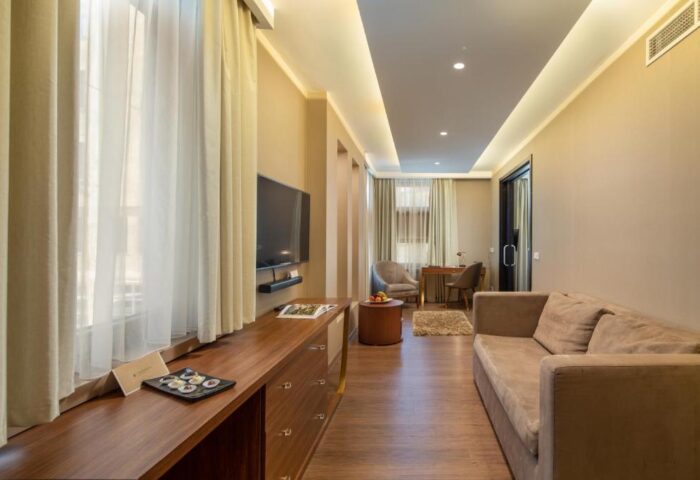 Continental Hotel room interior. Gay-friendly hotel with modern décor, sofa, desk, TV, and natural light. Ideal for gay men travel.