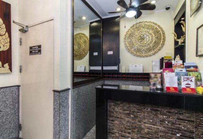 Copa Hotel's reception area. A gay-friendly hotel featuring a decorative wall art, a ceiling fan, and a modern front desk with travel brochures.