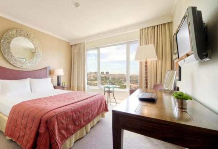 Corinthia Hotel Lisbon room. Gay-friendly, pet-friendly hotel with bed, desk, and city views. Ideal for gay travel in Lisbon.