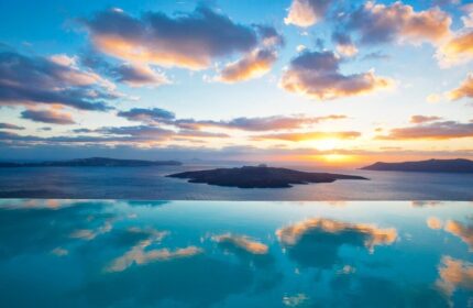 Sunset view from Cosmopolitan Suites, a gay-friendly hotel. Infinity pool reflects the sky over the Aegean Sea. Ideal for gay travel.