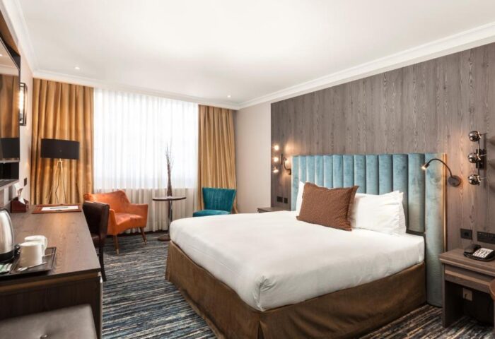 Courthouse Hotel bedroom. Gay-friendly, pet-friendly hotel room with king bed, desk, and chairs. Modern design, perfect for gay travelers.
