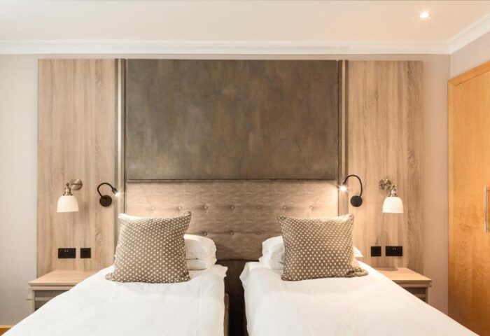Courthouse Hotel gay-friendly room with two beds, stylish headboard, bedside tables, and lamps. Pet-friendly hotel for gay men travel.