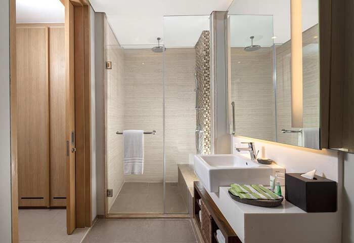 Bathroom at Courtyard Bali Seminyak Resort, a gay-friendly hotel. Features a walk-in shower, modern sink, and sleek design. Ideal for gay travel.