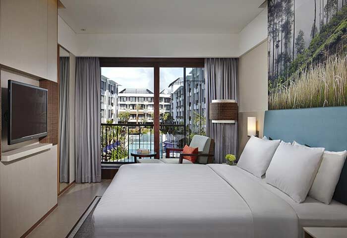 Courtyard Bali Seminyak Resort room with balcony view. Gay-friendly hotel featuring a comfortable bed, TV, and stylish decor for gay men travelers.