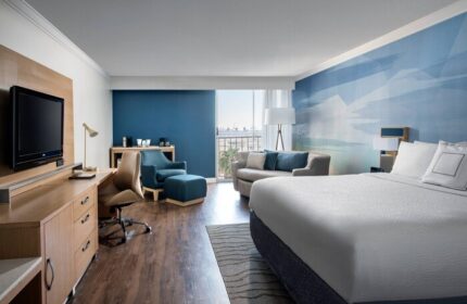 Courtyard Long Beach Downtown gay-friendly hotel room. King bed, desk, TV, sofa, and balcony. Modern design and comfortable amenities.