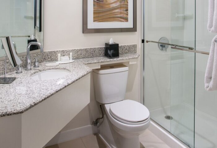 Bathroom at Gay-Friendly Courtyard Long Beach Downtown hotel. Sink, toilet, shower, granite countertop, and modern design. Great for gay travel.