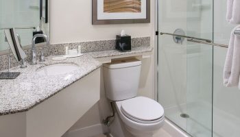 Bathroom at Gay-Friendly Courtyard Long Beach Downtown hotel. Sink, toilet, shower, granite countertop, and modern design. Great for gay travel.