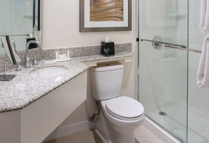 Bathroom at Gay-Friendly Courtyard Long Beach Downtown hotel. Sink, toilet, shower, granite countertop, and modern design. Great for gay travel.