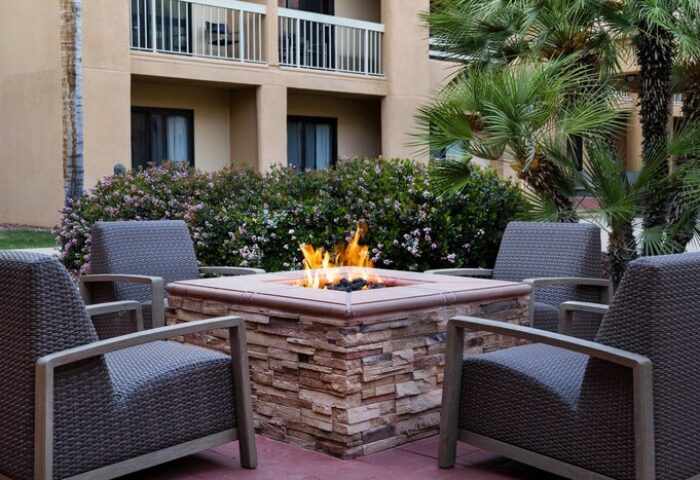 Courtyard Palm Springs gay-friendly hotel fire pit. Outdoor seating, palm trees, and a welcoming ambiance for gay travelers. Relax and enjoy.