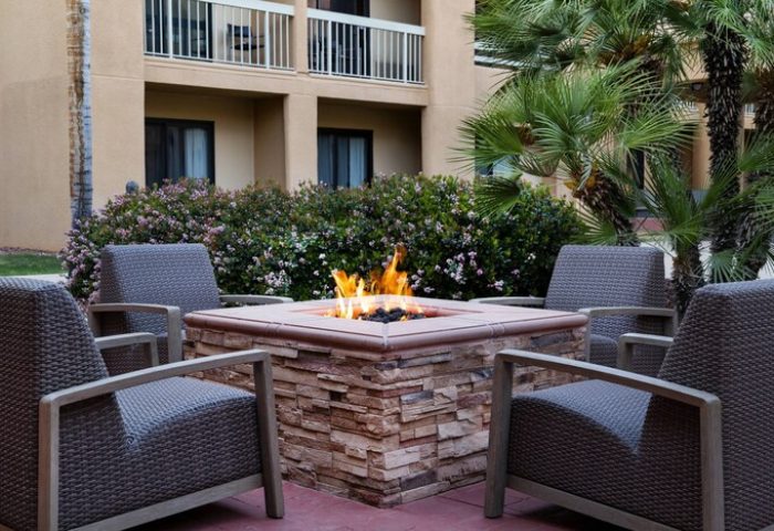 Courtyard Palm Springs gay-friendly hotel fire pit. Outdoor seating, palm trees, and a welcoming ambiance for gay travelers. Relax and enjoy.