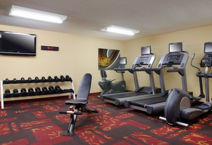 Courtyard Palm Springs gay-friendly hotel gym. Treadmills, weights, and exercise bike for guests' fitness. Hotel gym with modern equipment.