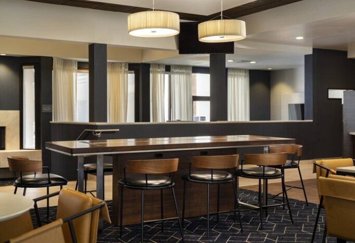 Courtyard Palm Springs gay-friendly hotel interior. Lounge area with high-top table, chairs, and modern lighting. Stylish design.