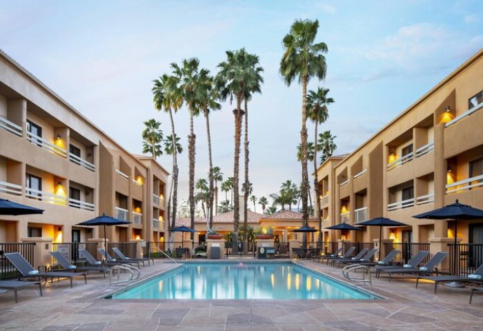 Courtyard Palm Springs gay-friendly hotel. Swimming pool and palm trees at the Courtyard in Palm Springs, California. Gay travel advice.