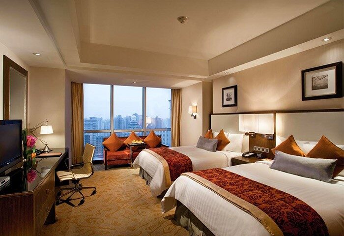 Courtyard by Marriott Shanghai Xujiahui gay-friendly hotel room with two beds, desk, and city view. Perfect for gay travelers.