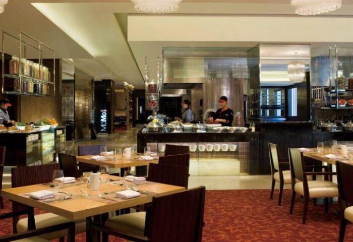 Courtyard by Marriott Shanghai Xujiahui's restaurant. Gay-friendly hotel dining area with tables, chairs, and buffet. Upscale interior.