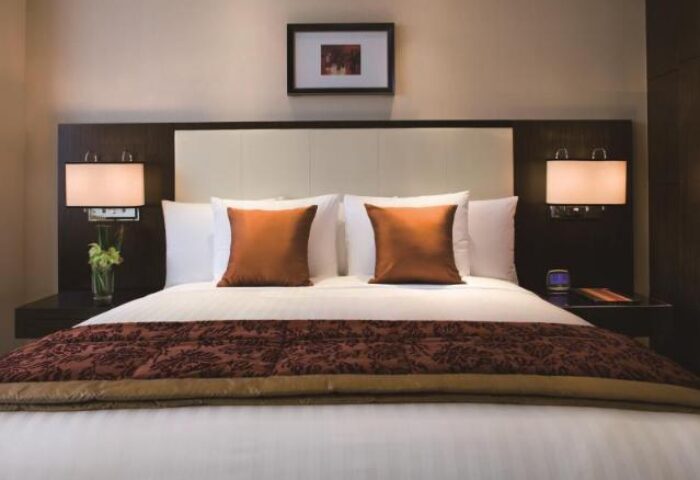 Courtyard by Marriott Shanghai Xujiahui's room. Gay-friendly hotel with a comfortable bed, pillows, lamps and a picture. Perfect for gay travelers.