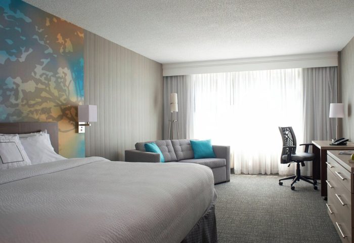 Courtyard by Marriott Toronto Downtown hotel room. Gay-friendly accommodations with a king bed, sofa, desk, and modern decor.