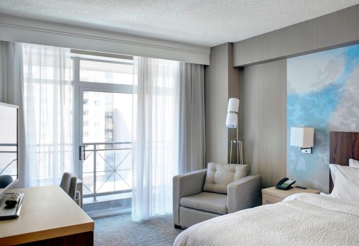 Courtyard by Marriott Toronto Downtown room. Gay-friendly hotel with balcony, desk, chair, and bed. Modern design. Ideal for gay travel.