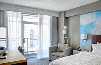 Courtyard by Marriott Toronto Downtown room. Gay-friendly hotel with balcony, desk, chair, and bed. Modern design. Ideal for gay travel.