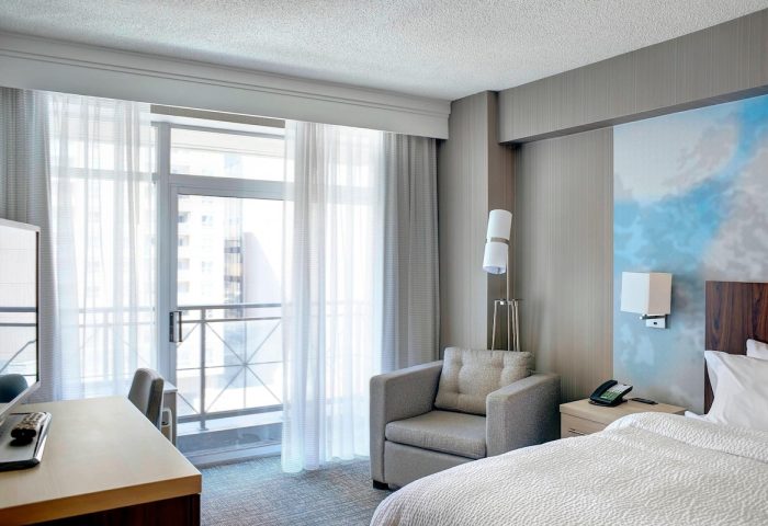 Courtyard by Marriott Toronto Downtown room. Gay-friendly hotel with balcony, desk, chair, and bed. Modern design. Ideal for gay travel.